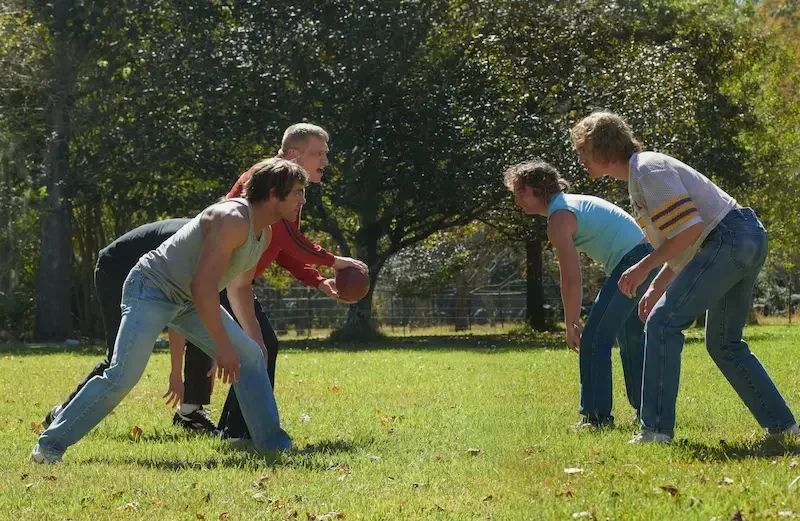 the iron claw szene: ein vater spielt mit seinen Söhnen Football