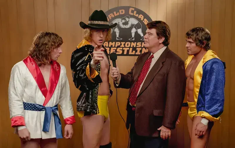 the iron claw szene: drei wrestler und ein moderator beim interview