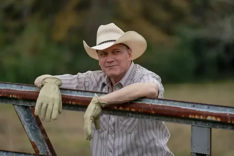 the iron claw szene: ein mann mit cowboy hut an einem Gatter