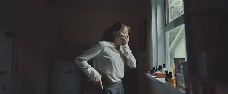 lee harker geschockt vor einem küchenfenster