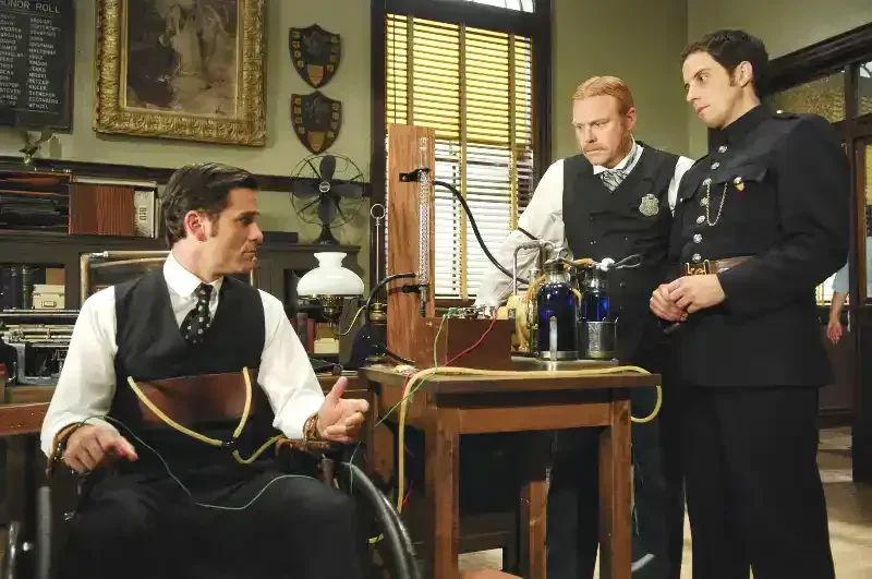 Murdoch Mysteries Staffel 1 Szenenbild: drei Männer diskutieren über Wissenschaftsexperiment im Büro.