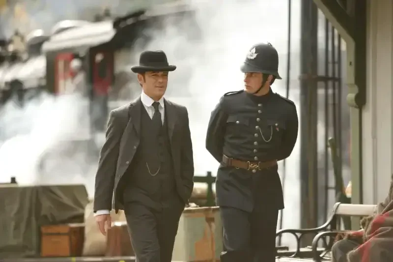 Murdoch Mysteries Staffel 1 Szenenbild: Historiche Szene mit zwei Männern und Dampflokomotive.