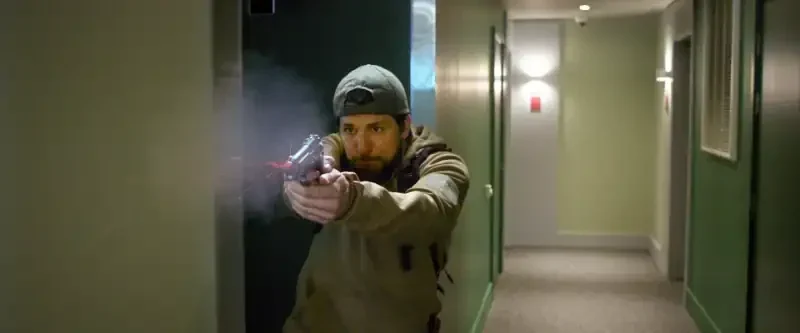 Take Cover Filmszene: Mann mit Pistole in einem Flur schießt