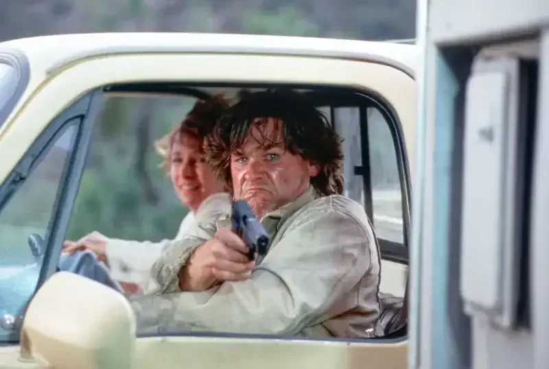 Breakdown Filmszene: Mann zielt mit Pistole aus Autofenster