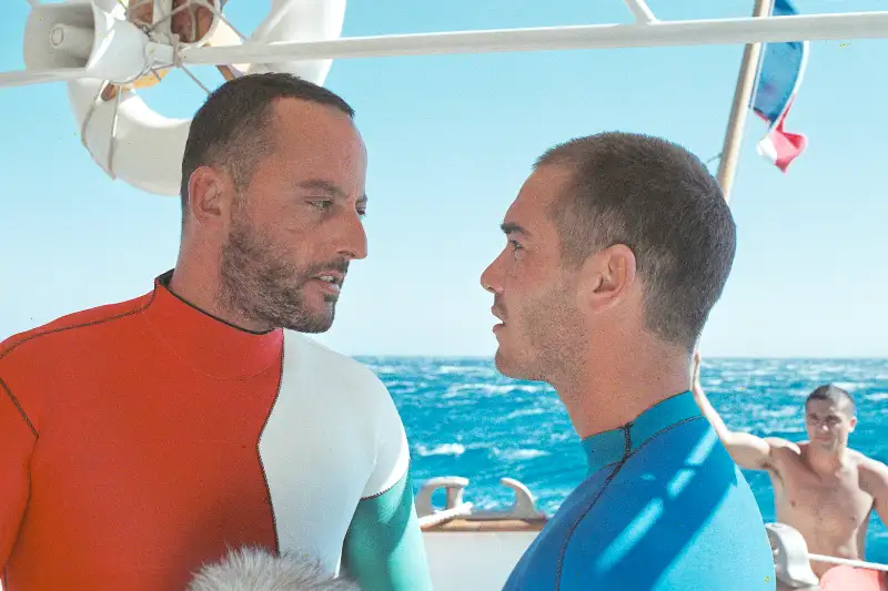 Im Rausch der Tiefe Titelbild: Jean Reno und Jean-Marc Barr in Taucheranzügen auf einem Boot.