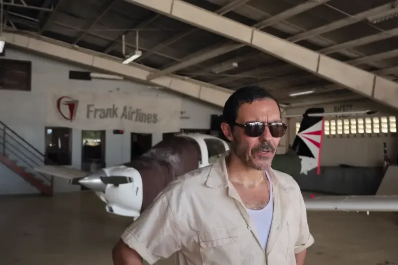 The Bayou Filmszene - Pilot vor Flugzeug in Hangar