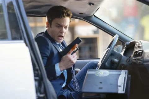Mr. No Pain - Novocaine - Filmkritik Titelbild: Mann sitzt in Polizeiauto und hält Waffe in der Hand