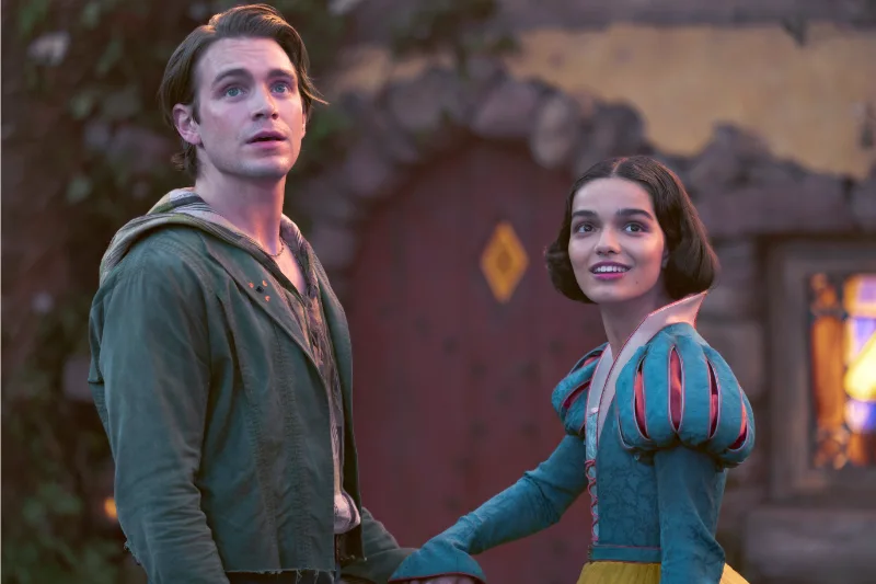 Schneewittchen 2025 Filmszene: Zwei Personen in Märchenkostümen vor einem Haus.