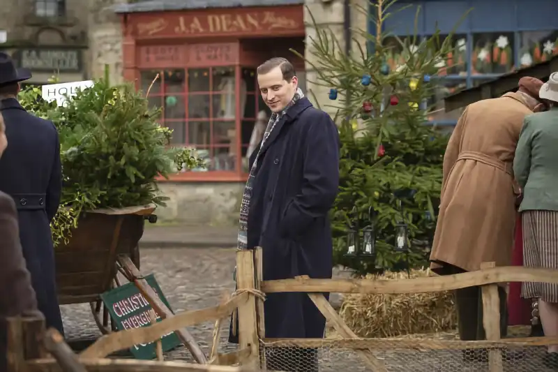 Der Doktor und das liebe Vieh Staffel 1 Szene: Mann auf Weihnachtsmarkt mit Weihnachtsbaum und Krippe.