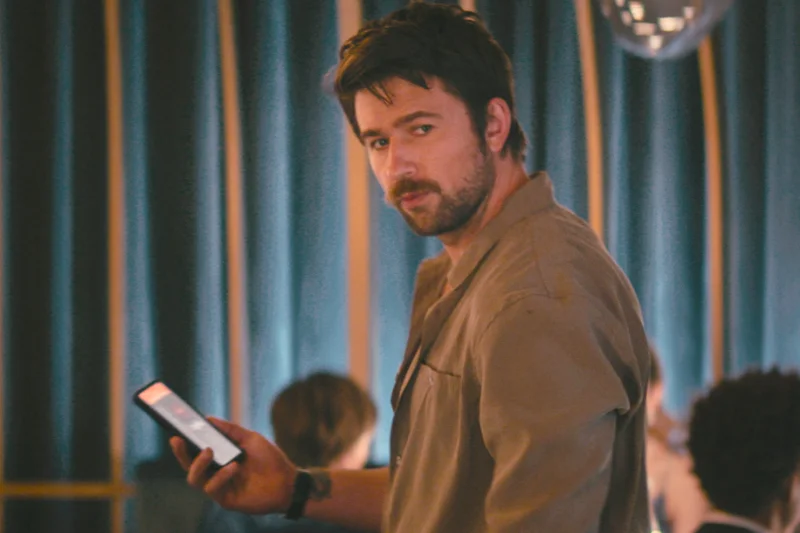 Drop Tödliches Date Filmszene: Mann mit Smartphone in modernem Raum