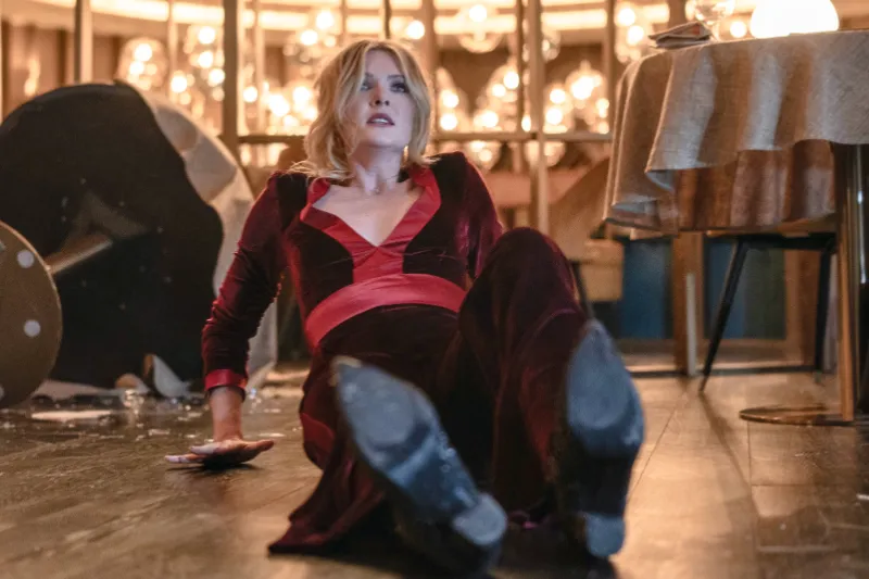 Drop Tödliches Date Filmszene: Frau in rotem Kleid sitzt auf dem Boden.