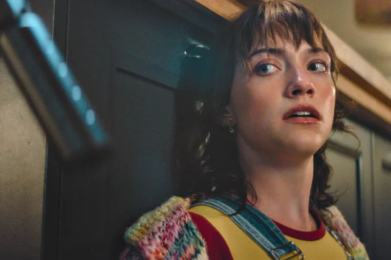 Drop Tödliches Date Filmszene: Frau schaut ängstlich, im Hintergrund Pistole sichtbar.