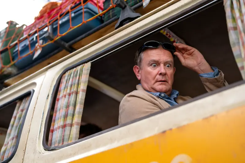 Paddington in Peru Filmszene: Mann schaut aus einem farbigen Busfenster heraus.