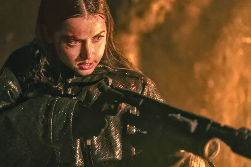 Darstellerin Ana de Armas im dunkeln mit gewehr im anschlag