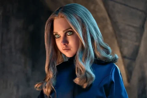 Killder-Android M3GAN mit blonden Haaren, blauen Augen in Kellergewölbe