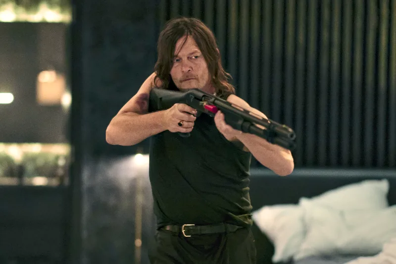 Schauspieler Norman Reedus als Daniel mit Schrotflinte in einem Hotelzimmer