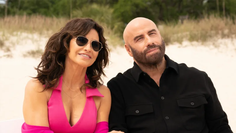Gina Gershon als Amelia und John Travolta als Mason in einer Strandszene aus Cash Out 2