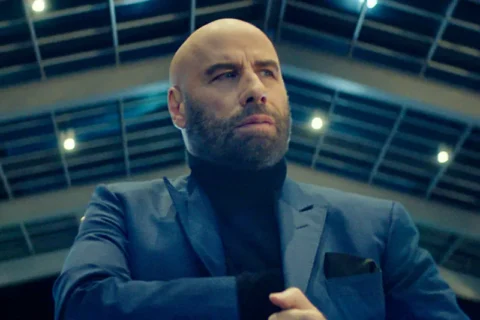 John Travolta als Mason Goddard mit blauem Anzug in einer Eingangshalle - Filmszene aus Cash Out 2