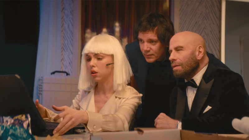 Szene aus Cash Out 2: John Travolta, Lukas Haas und Natali Yuri beraten sich vor einem Laptop