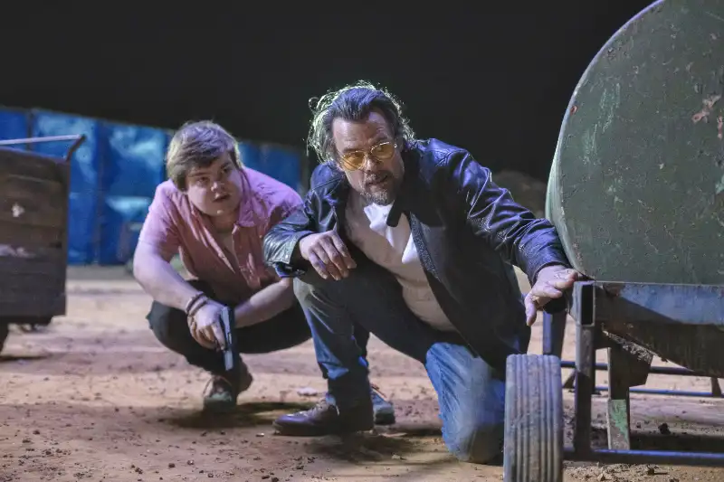 Darsteller Jeremy Ray Taylor und Josh Duhammel als Julian und Tommy im dunkeln, kniend im Sand mit Pistole -Filmszene