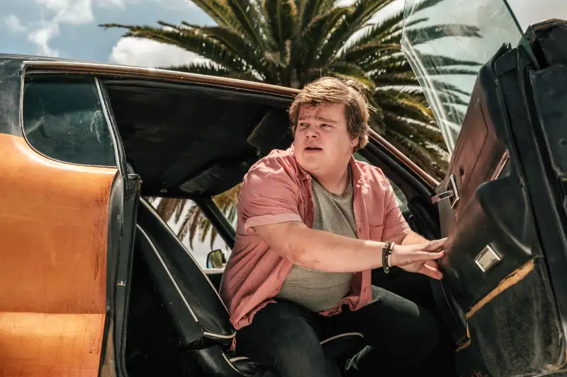 Darsteller Jeremy Ray Taylor steigt in einer Filmszene aus einem orangenen Auto