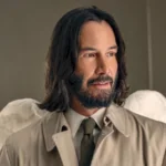 Keanu Reeves mit Bart, Engelsflügeln und Trenchcoat - Szene aus Good Fortune