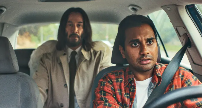 Keanu Reeves mit Engelsfügeln und Azis Ansari am Steuer im Auto - Filmszene Good Forutne