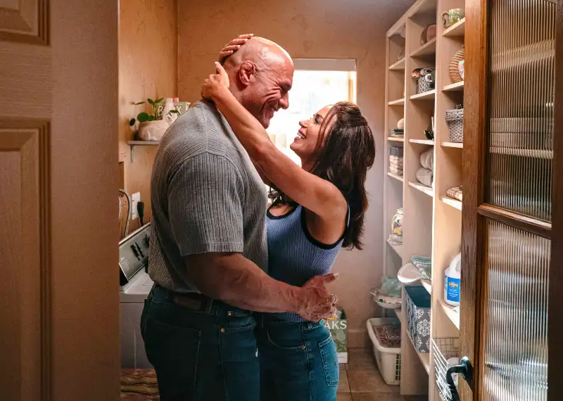 Darsteller Dwayne Johnson mit Emily Blunt umarmen sich in einem Wäschezimmer mit Waschmaschine - Filmszene aus Smashing Machine