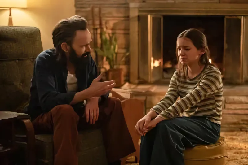 Ein Vater mit Bart unterhält sich im Wohnzimmer mit seiner jungen Tochter -Black Phone Filmszene