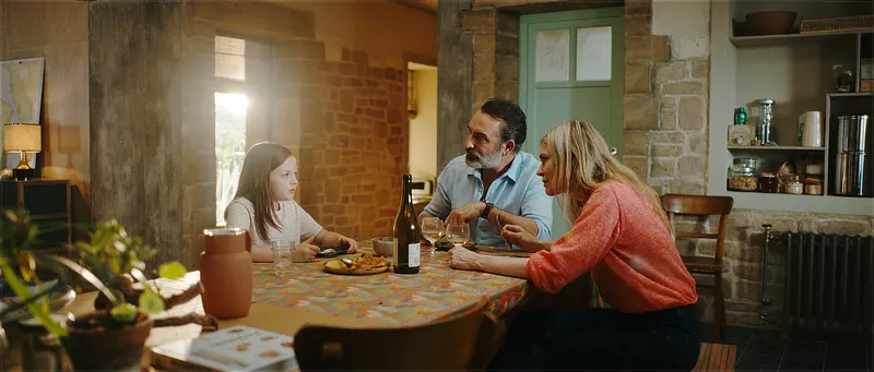 Jean Dujardin als Paul mit Frau und Tochter am Esstisch - Filmszene - Der Mann der immer kleiner wurde