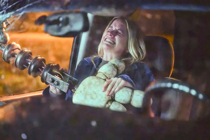 Ein Frau wird von einem Roboterarm in den Autositz gedrückt - Five Nights at Freddy's 2