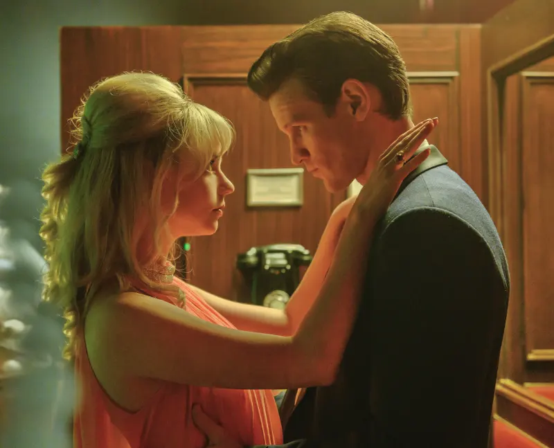Frau und Mann umarmen sich, vor einem Telefon in einem Club - Filmszene aus Last Night in Soho