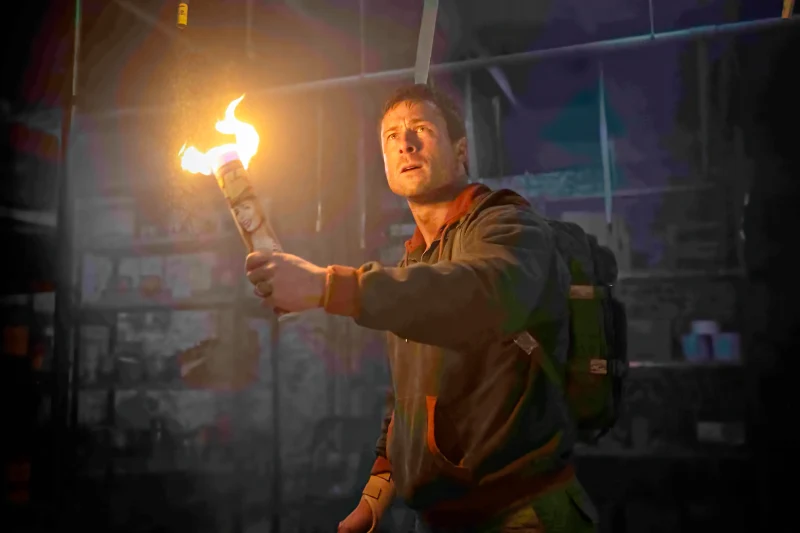 Mann mit brennender Fackel in dunklem Gebäude - Szene The Running Man 2025