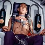 Schauspieler Ian Hendry als John Kane beim Astronauten Belastungstest in einem Raketen-Simulator - Filmszene Unfall im Weltraum