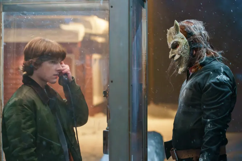 Mason Thames als Finn und Ethan Hawke mit Greifer Maske in einer Telefonzellen Szene aus Black Phone 2