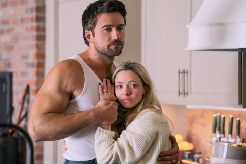 Brendan Sklenar als Andrew, hält Amanda Seyfried als Nina fest, die aufgewühlt dreinschaut - Szene aus The Housemaid