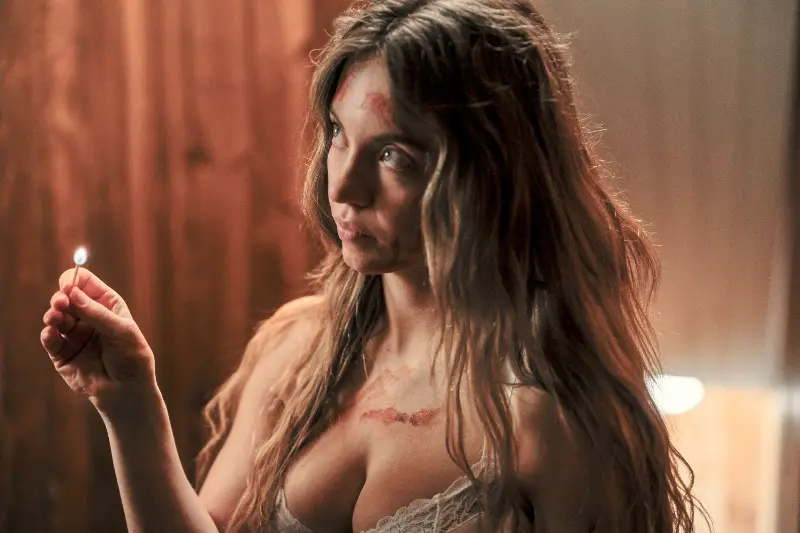 Sydney Sweeney als Millie hält ein Streichholz ihr Gesicht und Körper sind blutbefleckt - Szene aus The Housemaid