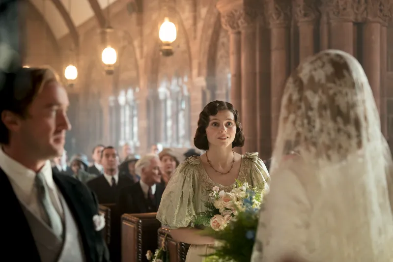 Hochzeitsszene in historischer Kirche mit Brautjungfer und Blumen