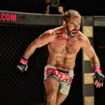Ein muskulöser MMA-Kämpfer greift schreiend seinen Gegner im Käfig an.