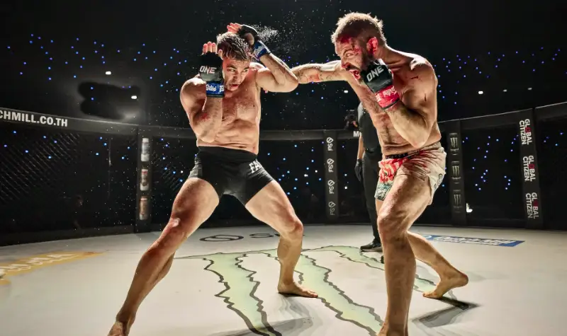 Zwei blutverschmierte MMA-Kämpfer während eines intensiven Kampfes im Ring.