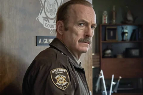 Bob Odenkirk als Sheriff Ulysses in Uniform im Büro – Szene aus dem Film Normal
