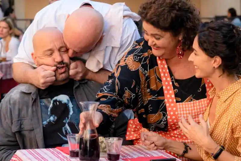Schauspieler Kevin James als Matt mit drei Personen an einem Tisch mit Rotwein - Filmszene aus Solo Mio