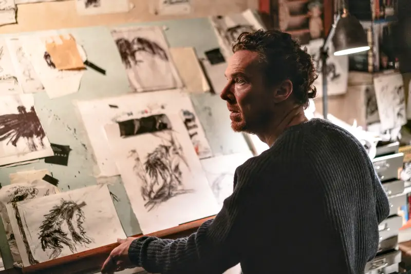 Benedict Cumberbatch sitzt aufgeschreckt vor einem Zeichenbrett voller düsterer Monster-Skizzen
