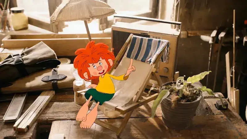 pumuckl in einem puppensonnenstuhl auf der werkbank