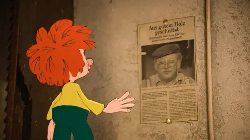 pumuckl vor einem zeitungsauschnitt mit gustl bayrhammer drauf